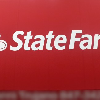 Process: applying the white logo via stencil onto fabric pre-painted in State Farm red, previous employer